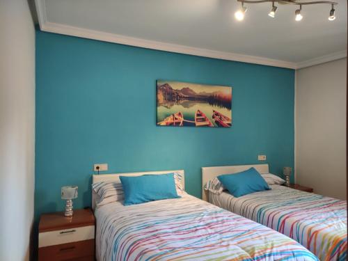 2 camas en una habitación con paredes azules en Apartamento Toki Berriya en Elizondo
