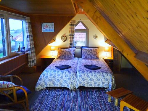 ein Schlafzimmer mit einem großen Bett im Dachgeschoss in der Unterkunft Vloed in Callantsoog
