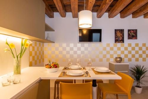 a kitchen with yellow chairs and a white table with glasses at TIFFANY GOLD in Burano