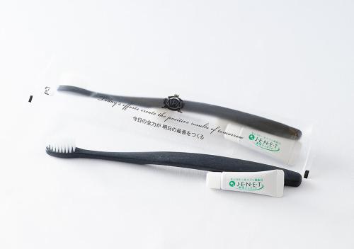 a toothbrush and a toothpaste tube on a white background at APA Hotel & Resort Niigata Ekimae Odori in Niigata