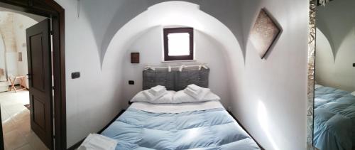 a bedroom with two beds in a room with a mirror at Luxury Trulli Sabotino 48 in Alberobello