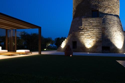a person sitting on a lawn in front of a building at Torre Granitola Suite in Granitola