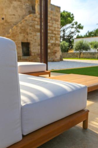 two beds sitting on a wooden bench on a patio at Torre Granitola Suite in Granitola
