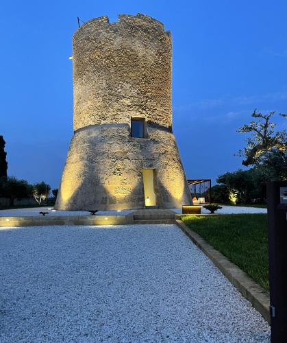 a building with a tower with a yellow door at Torre Granitola Suite in Granitola