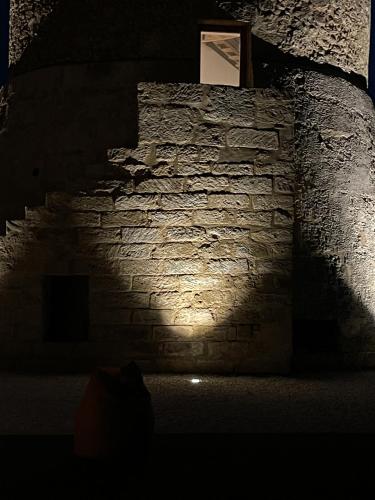 a dark room with a stone wall with a light on it at Torre Granitola Suite in Granitola