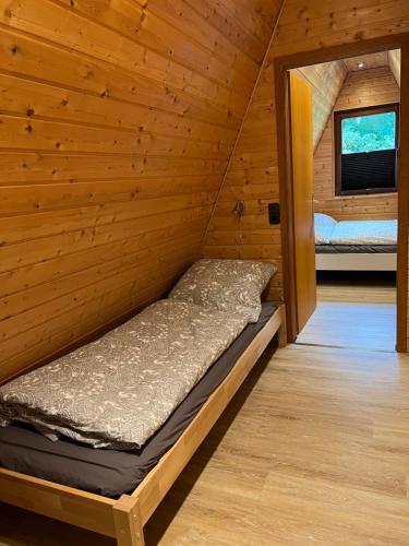 Bett in einer Holzhütte mit Fenster in der Unterkunft Haus Luzia in Meschede