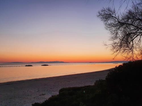 a view of a beach at sunset with the sun setting at Casa Marina - Monolocale vista mare in Follonica