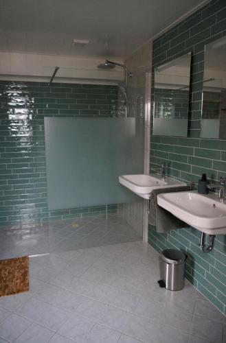 a bathroom with two sinks and a mirror at Bed and Breakfast het Groentje in Staphorst