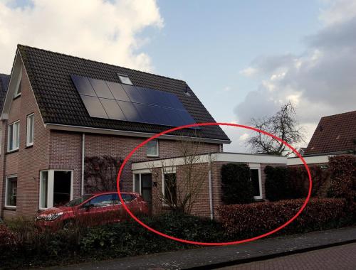 a house with a red circle in front of a house at Bed and Breakfast het Groentje in Staphorst