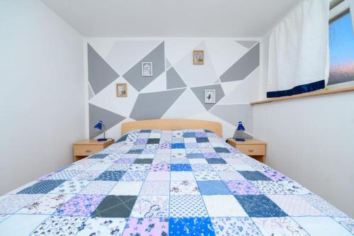 1 dormitorio con 1 cama con edredón en Apartmani Noris (app3) en Martinšćica