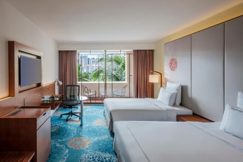 Habitación de hotel con 2 camas, escritorio y TV. en Paradox Singapore Merchant Court at Clarke Quay, en Singapur