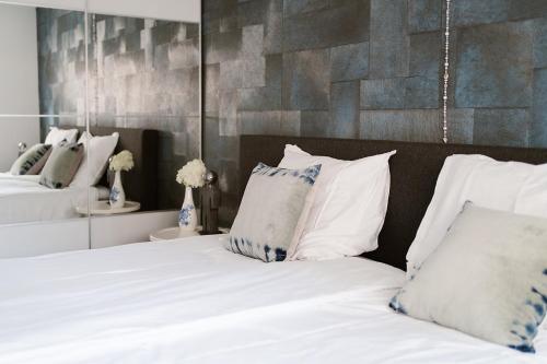 een slaapkamer met 2 bedden met witte lakens en kussens bij LodgeNr18 in Apeldoorn