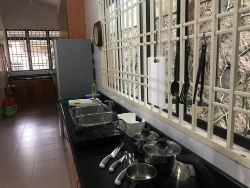 ジョホールバルにあるCosy big house 5min CIQ SOGO KSL mall 4BR 12Paxのキッチン(シンク、鍋とフライパン付きのカウンター付)