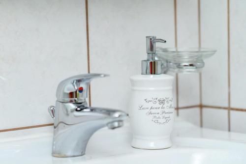 zlew w łazience z dozownikiem mydła obok kranu w obiekcie Apartmani Noris (app3) w mieście Martinšćica