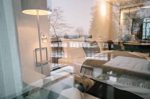 a glass window of a balcony with a table and chairs at Möhnestube mit Seeblick, Pool und Sauna in Möhnesee