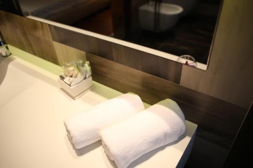 a bathroom with two towels on a counter with a mirror at Hotel IN in Međugorje