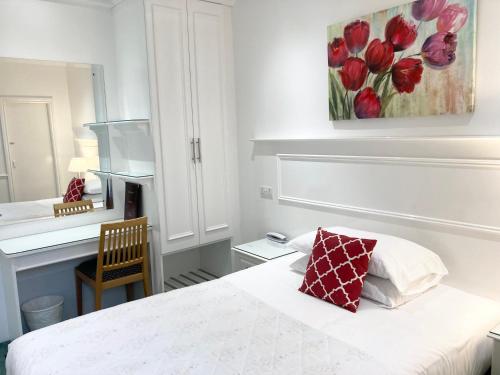 a bedroom with a bed and a painting on the wall at Dergvale Hotel in Dublin