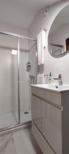 a white bathroom with a shower and a sink at Casa na Costa in Costa Nova