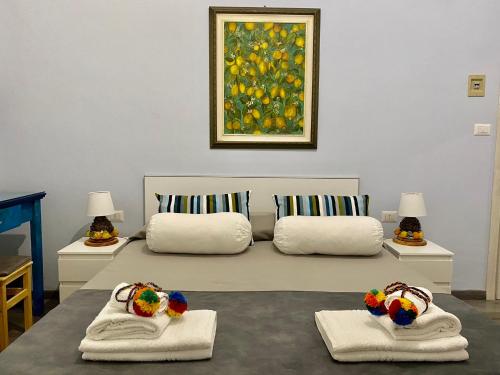 1 dormitorio con 1 cama con 2 toallas y 1 pintura en Chiaro di Luna, en Taormina