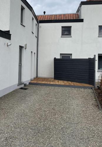 a white house with a black fence and a driveway at L'Entre-Temps in Xhendelesse
