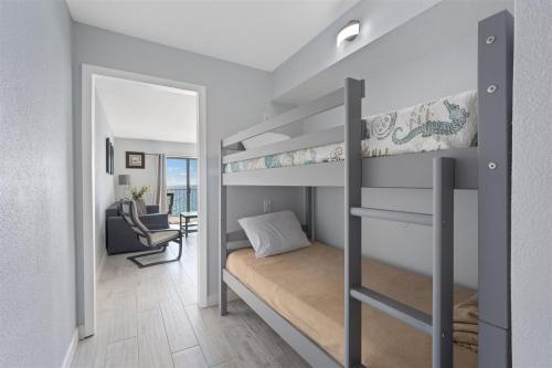 a bedroom with bunk beds and a living room at The Summit 1006 in Panama City Beach