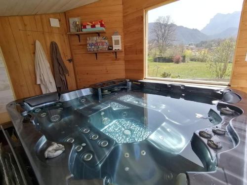 a bath tub in a room with a window at Chambre familiale "le pêcher" in Saillans