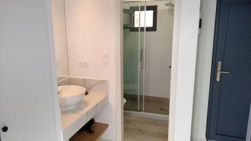 a bathroom with a sink and a glass shower at Minois Boutique Hotel in Stalida