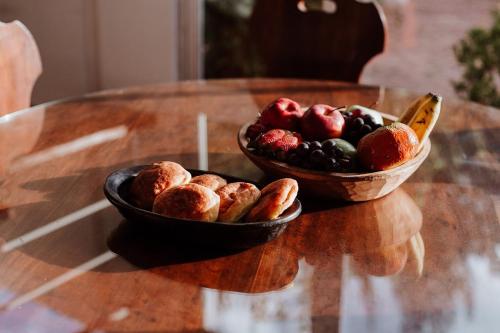 a bowl of fruit and a bowl of bread on a table at Chalet Andino Sesquile in Suesca