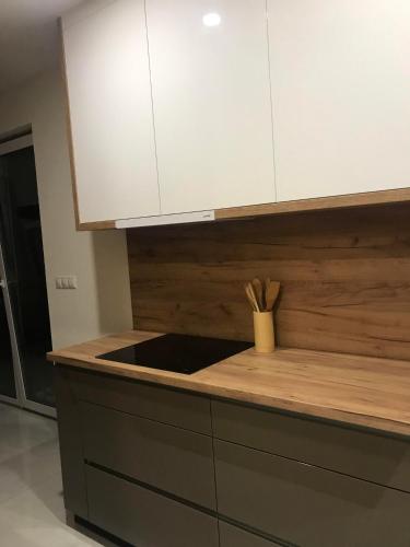 a kitchen with a counter top with white cabinets at Apartmán s vyhliadkou in Bojnice