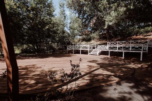a white bench sitting in a park with trees at Chalet Andino Sesquile in Suesca