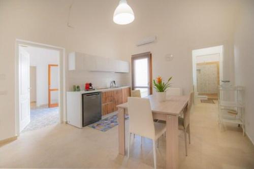 a kitchen with a table and a dining room at Antiche Dimore in Mazara del Vallo