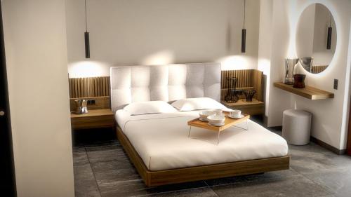 1 dormitorio con cama blanca y mesa en Viva Mare Studios, en Astipalea
