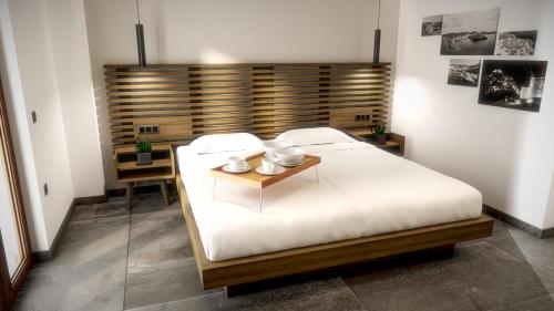 1 dormitorio con cama blanca y cabecero de madera en Viva Mare Studios, en Astipalea