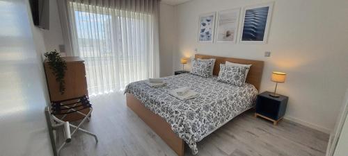 a small bedroom with a bed and a window at Pé n'Areia Guesthouse in Vila do Conde