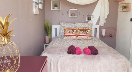 a bedroom with a bed with pink slippers on it at ARCACHON PETIT PORT - T3 VUE BASSIN in Arcachon