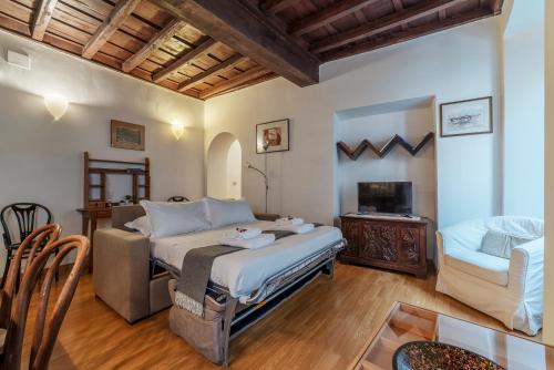 1 dormitorio con cama, sofá y mesa en Tucked away and quiet by Piazza Navona - FromHometoRome en Roma