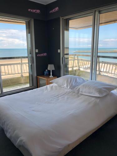 une chambre avec un lit avec vue sur l'océan dans l'établissement Royal Seavieuw, à Calais