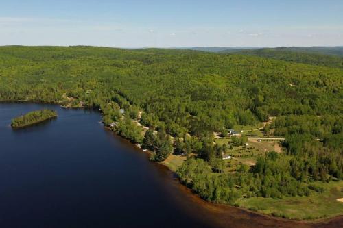 an aerial view of a lake with trees and water at Chalet le Huard directement au bord du lac in Saint Zenon