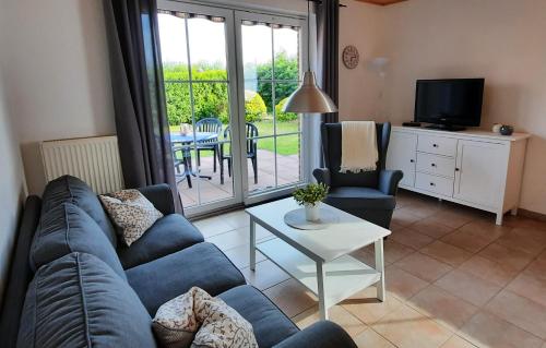 a living room with a blue couch and a table at Ferienhaus Luetje-Huuske in Krummhörn