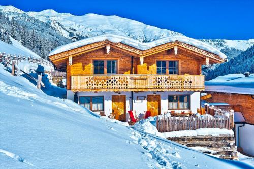 a log cabin with a balcony in the snow at Alpendorf Anno Dazumal in Tux