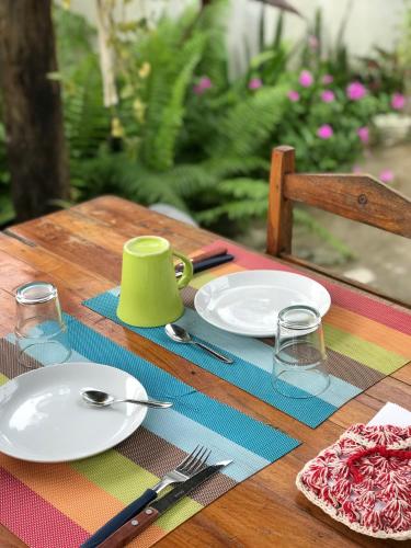 a wooden table with plates and utensils on it at Pousada kaz'oca in Icaraí