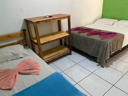 a room with two beds and a small table at Estância Cyclo das Águas in Nobres