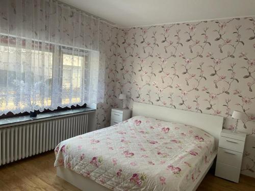 a bedroom with a bed with a floral wallpaper at Ferienwohnung M&M in Herford