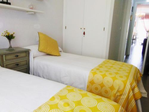 アリカンテにあるLuminoso y acogedor apto-1 Dorm-AAのベッドルーム1室(黄色と白のシーツを使用したベッド2台付)