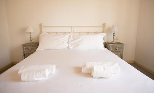 two towels are sitting on a white bed at Griante suites in Griante Cadenabbia