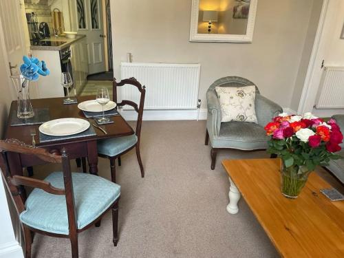 jadalnia ze stołem i krzesłami oraz wazonem kwiatów w obiekcie Lovely 1 bed flat in Victorian house 300m seafront w mieście Penzance