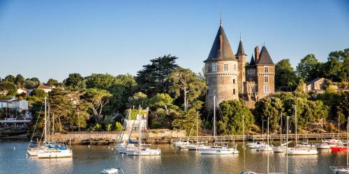 a group of boats in the water in front of a castle at Studio Pornic Golf avec piscine, 7 nuits mini, 2 personnes in Pornic