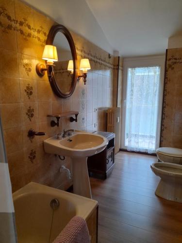 a bathroom with a sink and a mirror and a tub at casa vacanze morà 2 in Roccaforte Mondovì