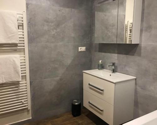 a bathroom with a white sink and a mirror at Apartmán s vyhliadkou in Bojnice