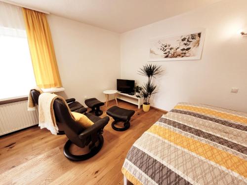 a bedroom with a bed and a chair and a desk at Apartment Sonnenschein in Dornbirn